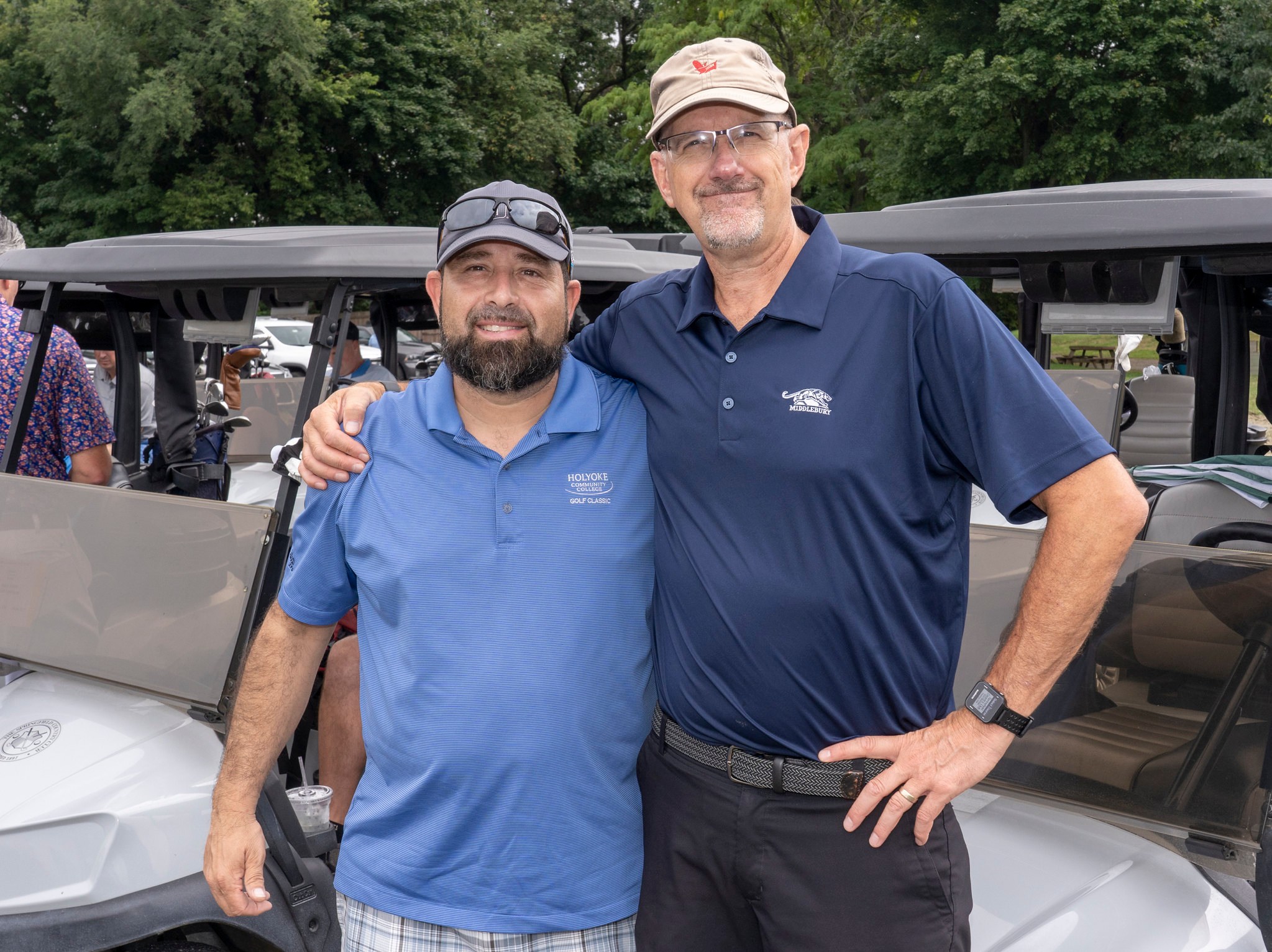 Admissions counselor Harold Santiago and media relations chief Chris Yurko in front of golf carts.